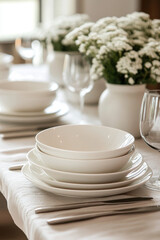 Fototapeta premium Table set with white plates and glasses, reflecting warm sunlight in an elegantly arranged dining setting.