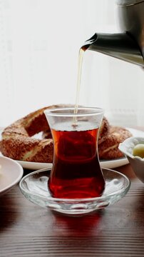 Local Turkish breakfast table Turkish tea, su boregi, green olives and simit bagel	