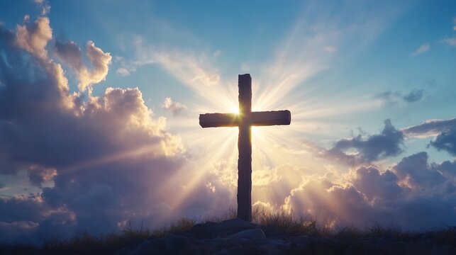 Silhouette of a cross at dawn with rays of light breaking through clouds representing resurrection