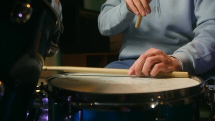 Focused drummer playing energizing rhythms on drum set in studio setting, emphasizing dedication technique musical expression during intense rehearsal moments. Drummer plays on snare drums and hi hat.