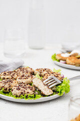 Vegan meat patties that cook like meat and have the same texture with green salad on a light concrete background. Delicious vegan food