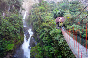 Suspended bridge and waterfall in Banos, Equador. . High quality photo.