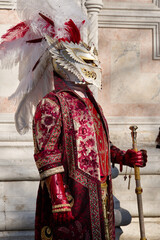 Venice, Italy - People dressed in carnival masks are photographed by tourists in the scenery of the ancient Venetian palaces