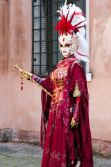 Venice, Italy - People dressed in carnival masks are photographed by tourists in the scenery of the ancient Venetian palaces