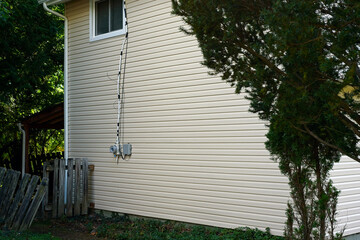 Side wall of a two-story house with new vinyl siding and gutter system