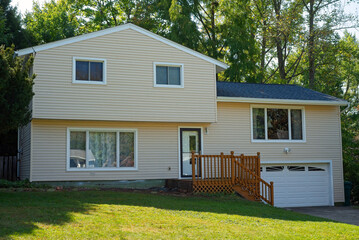 A split-level house with newly installed vinyl siding
