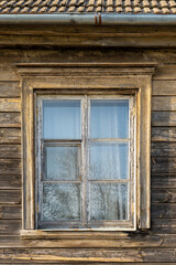 Close-Up of Weathered Wooden Window on an Old House in Latvia – Rustic Texture and Natural Reflection in Soft Spring Light
