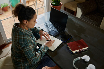 Woman Working Remotely on a Journal at a Modern Home Office Setting
