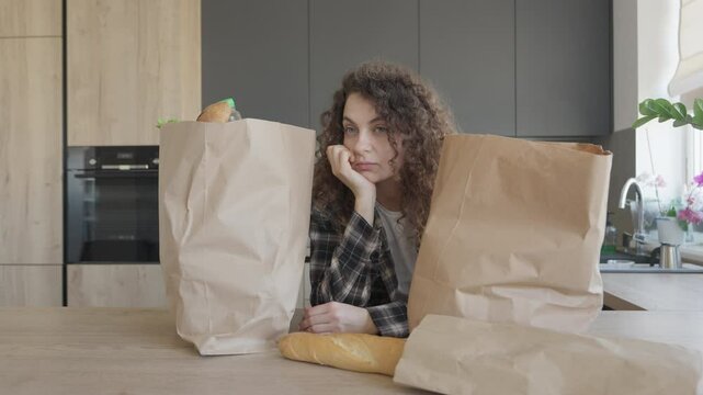 Woman Resting In Kitchen Before Unpacking Grocery Bags After Shopping Trip