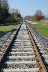 Obraz premium Railway Tracks Stretching Into a Clear Blue Sky