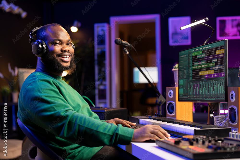 Poster portrait of skilled sound designer working in his home studio, adjusting volume levels on mixing con
