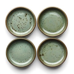 Four small, muted green ceramic plates, arranged in a square.