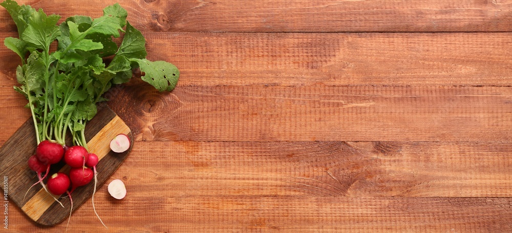 Wall mural board and fresh radish on wooden background with space for text, top view