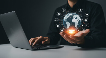Business concept images, clear concept, valuable images  a person working on a laptop while holding a digital globe with sustainability icons in their hand