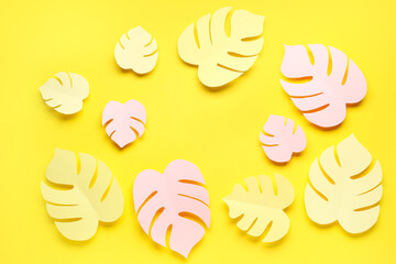 Frame made of paper tropical leaves on yellow background