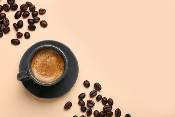 Cup of hot espresso and coffee beans on beige background