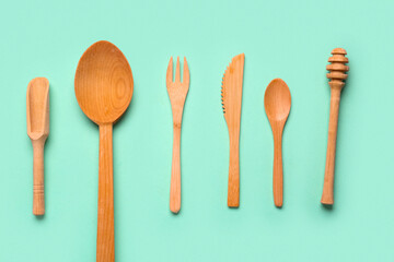 Wooden kitchen utensils on turquoise background