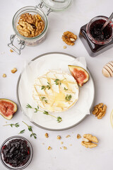 Plate of tasty baked Camembert cheese on grey background