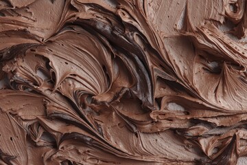 A close-up shot of rich, creamy chocolate frosting swirls, creating a delicious and inviting abstract texture for culinary backgrounds and dessert designs.
