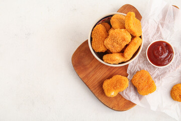 Bowl with tasty nuggets and ketchup on white background