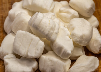 Brazilian coconut candy on a wooden board, aka bala de coco, a Brazilian artisanal party sweet made with coconut.