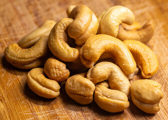 Cashew nuts. Handful of roasted cashew nuts on a wooden board.
