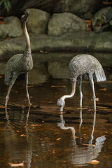 Bird statues in pond at Japanese Garden at The Butchart Gardens on Vancouver Island in British Columbia Canada in Fall