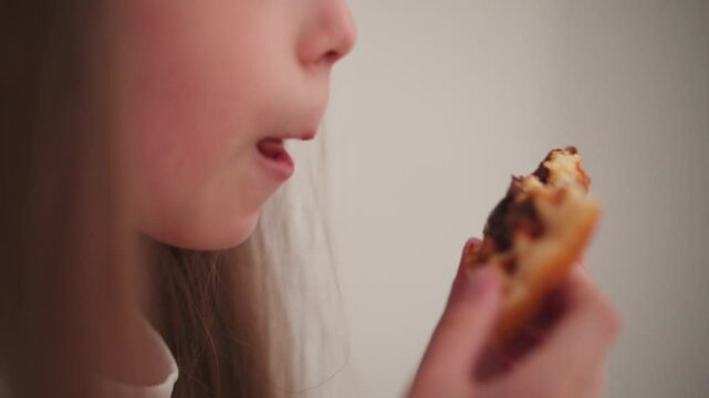 Close-up of kid licking melted chocolate from cookie with focused expression, capturing moment of sweet indulgence and joy in cozy indoor setting
