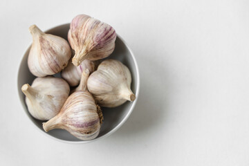 Bowl with fresh garlic on white background
