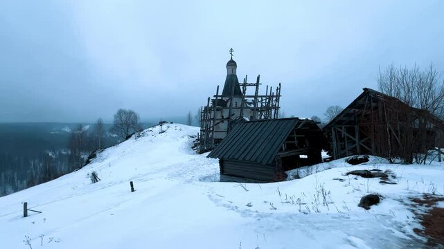 A log fortress wall covered with snow after a blizzard. Scenery for the film "The Heart of Parma" among snow-covered forests, hills and mountains in Perm Krai, Russia. The crooked cross in the Lip.4K	