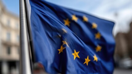 A close-up shot of the European Union flag waving in the wind, showing its stars.