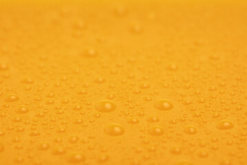 Yellow plastic background with water drops. Abstract yellow background.