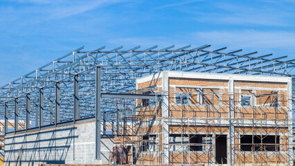 Construction of Building with Steel Frame. House Building Construction Site on blue sky background.