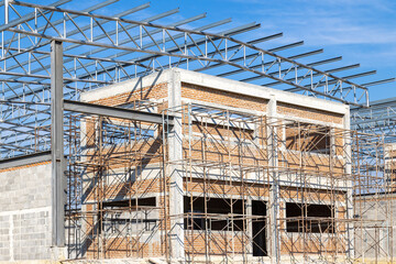 Construction of Building with Steel Frame. House Building Construction Site on blue sky background.