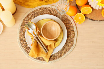Elegant table setting with beautiful narcissus flowers, cutlery in folded napkin and fresh oranges, top view