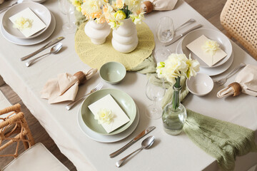 Elegant table setting with beautiful narcissus flowers, glasses and envelopes in bowls, top view