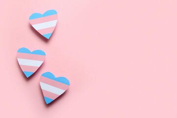 Transgender flag in shape of hearts on pink background