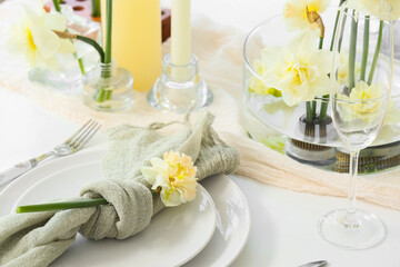 Beautiful table setting with narcissus flowers, closeup