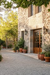 Fototapeta premium Nestled in a tranquil garden setting, this enchanting stone house features a grand wooden door framed by vibrant, lush greenery, all illuminated by the soft, warm glow of early evening light