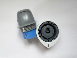 Close-up of glucose monitoring sensor and applicator on white background