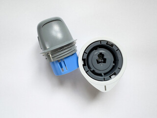 Close-up of glucose monitoring sensor and applicator on white background