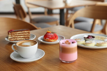 Delicious cottage cheese pancakes, desserts and aromatic coffee served on wooden table in cafe