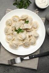 Delicious dumplings served on grey table, flat lay