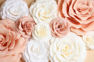 Beautiful paper flowers on beige background, flat lay