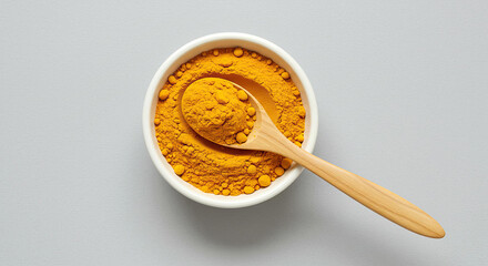 Healthy ritual turmeric powder bowl wooden spoon wholesome food element. Wholesome eating, healthy ritual, natural ingredient concept.
