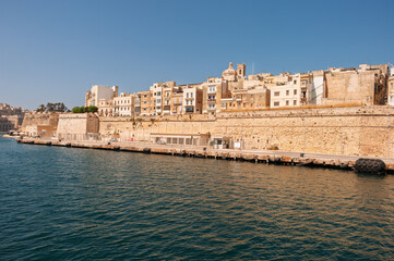 Fototapeta premium A city with a large wall and a body of water