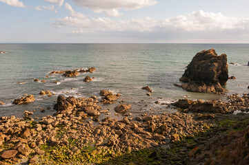 A rocky shoreline with a large rock in the foreground