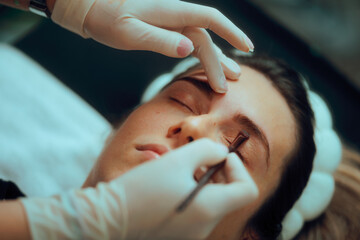 Beautician Finalizes the Stylized Shape of the Eyebrows of a Client. Meticulous process of...