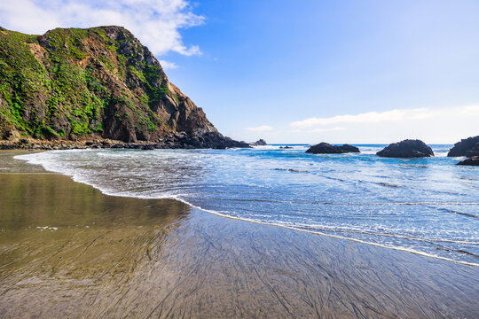 Breathtaking view of Pfeiffer Beach in Big Sur, California, featuring its iconic rock arch, golden sand, and turquoise waves. A stunning coastal landscape perfect for travel and nature lovers