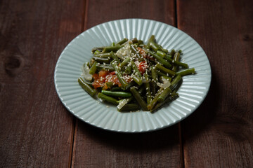 Tzimmes with green beans and tomatoes sprinkled with sesame seeds Jewish dish